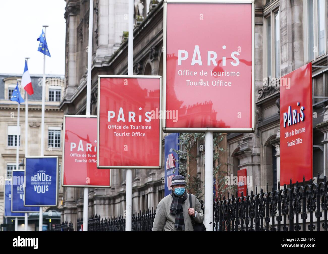 (210220) -- PARIS, Feb. 20, 2021 (Xinhua) -- A man wearing face mask walks past the Tourist Office located in the City Hall of Paris, France, Feb. 19, 2021. With 24,116 new infections confirmed in the last 24 hours, France has counted an accumulative total of 3,560,764 COVID-19 cases as of Friday, according to data from the French Public Health Agency. In a video conference with lawmakers from the ruling The Republic on the Move (LERM) party, President Emmanuel Macron said 'it's still too early to decide' whether to ease or tighten restrictions. 'We can consider hypotheses within 8 to 10 Stock Photo