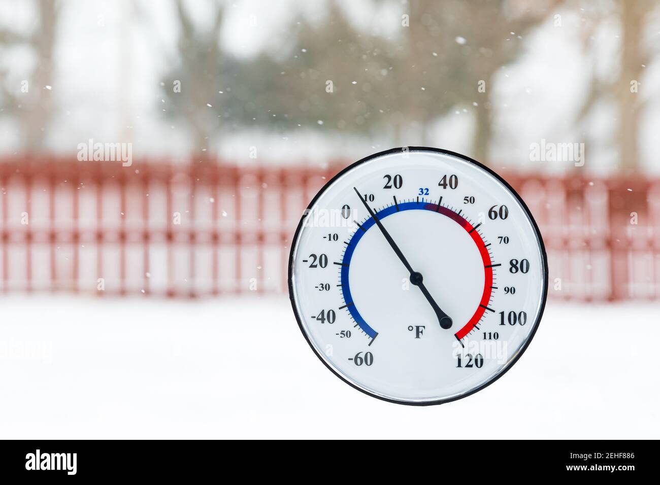 Thermometer showing cold temperature during winter snowstorm. Concept of freezing weather, cold temperature and winter safety Stock Photo