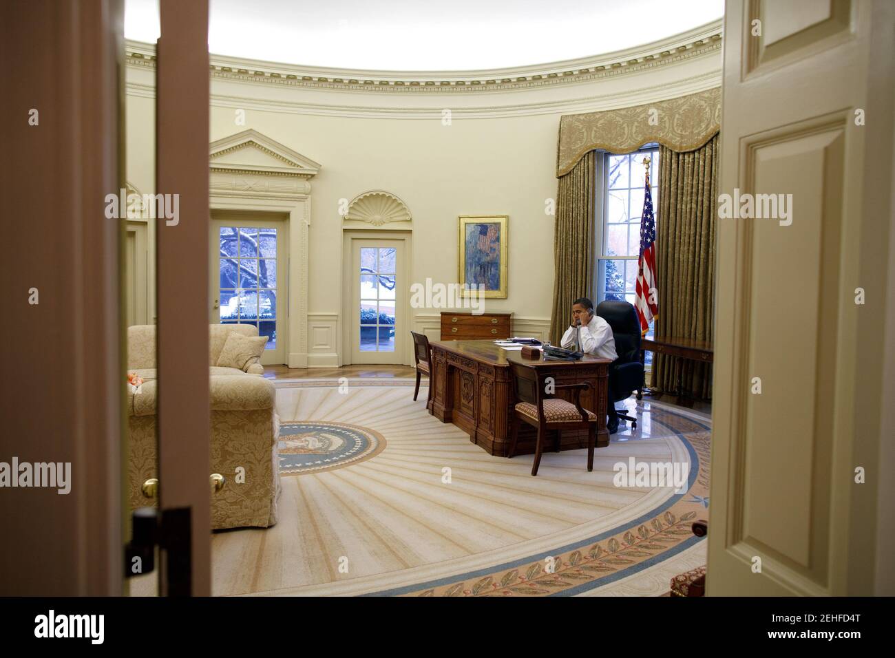 President Barack Obama talks on the phone in the Oval Office, Jan. 28 ...