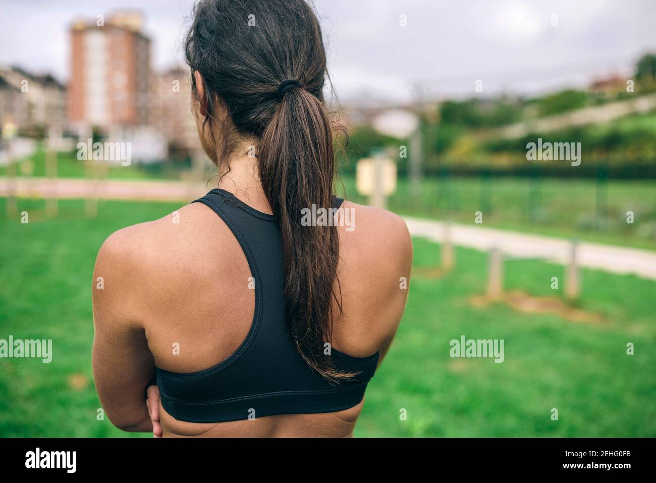 Unrecognizable young sportswoman training outdoors from behind Stock Photo
