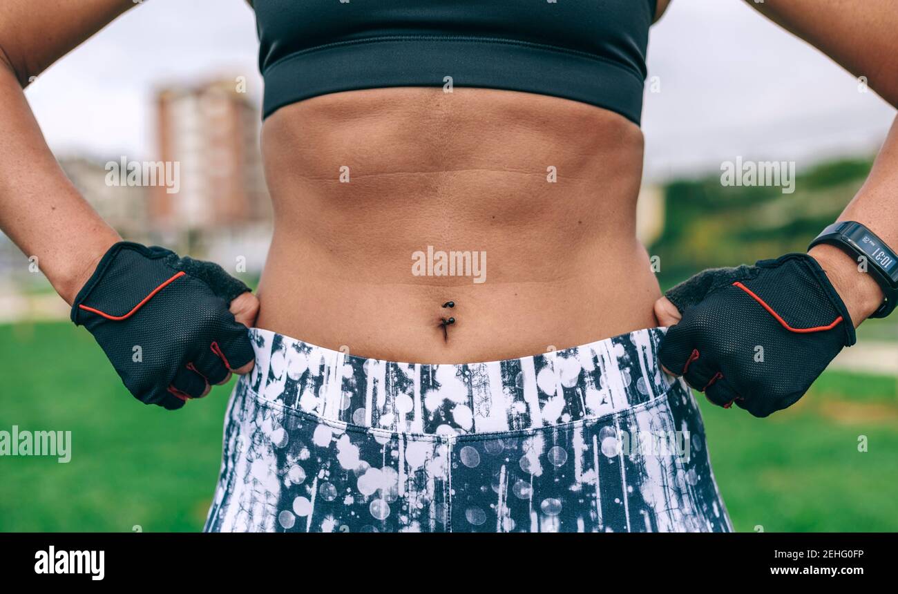Unrecognizable female athlete posing showing abdominal muscles Stock Photo