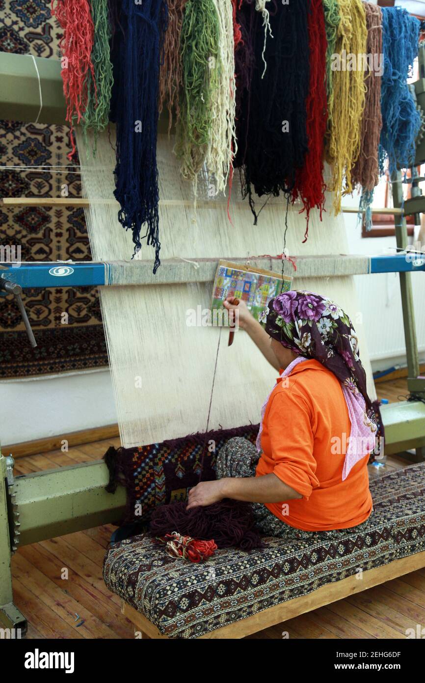A woman making Traditional Turkish Carpet at Cappadocia in Nevsehir, Turkey. Stock Photo