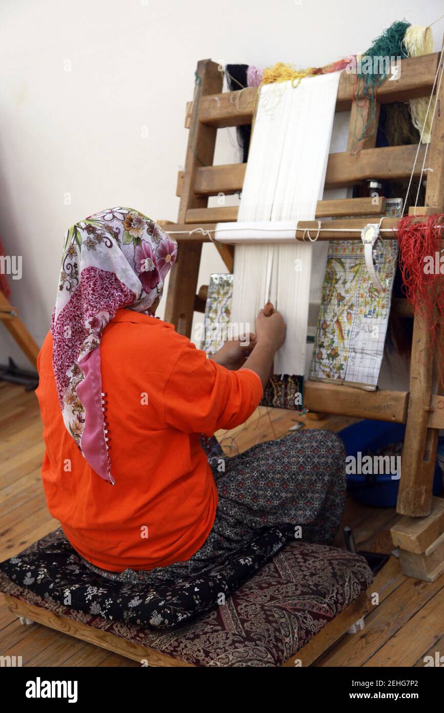 A woman making Traditional Turkish Carpet at Cappadocia in Nevsehir, Turkey. Stock Photo