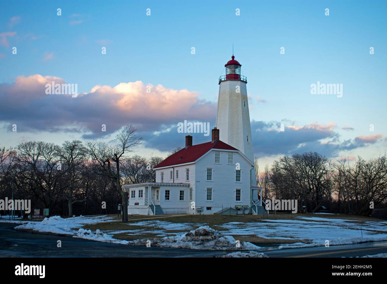 Lighthouse in Sandy Hook, New Jersey, in a late winter afternoon, with snow still on the ground and the light turned off  -39 Stock Photo