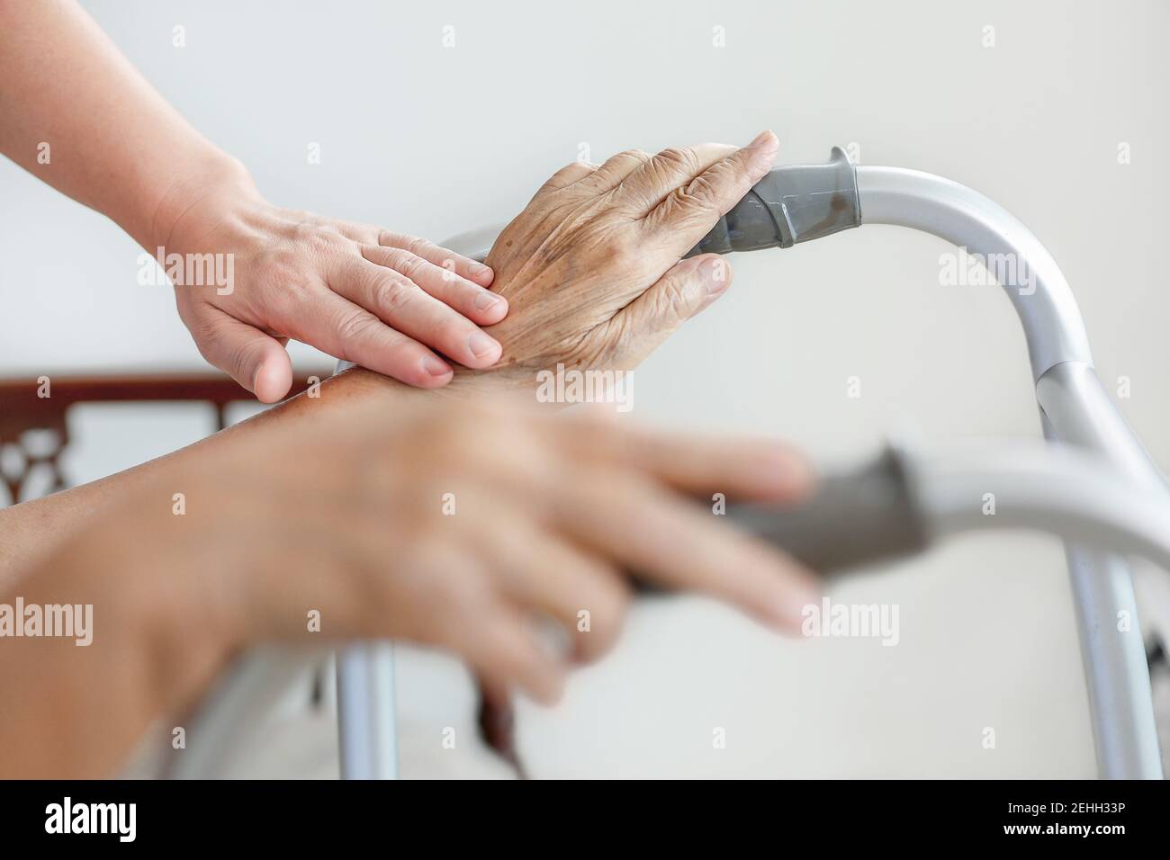 Elderly asian woman using a walker at home with caregiver take care Stock Photo