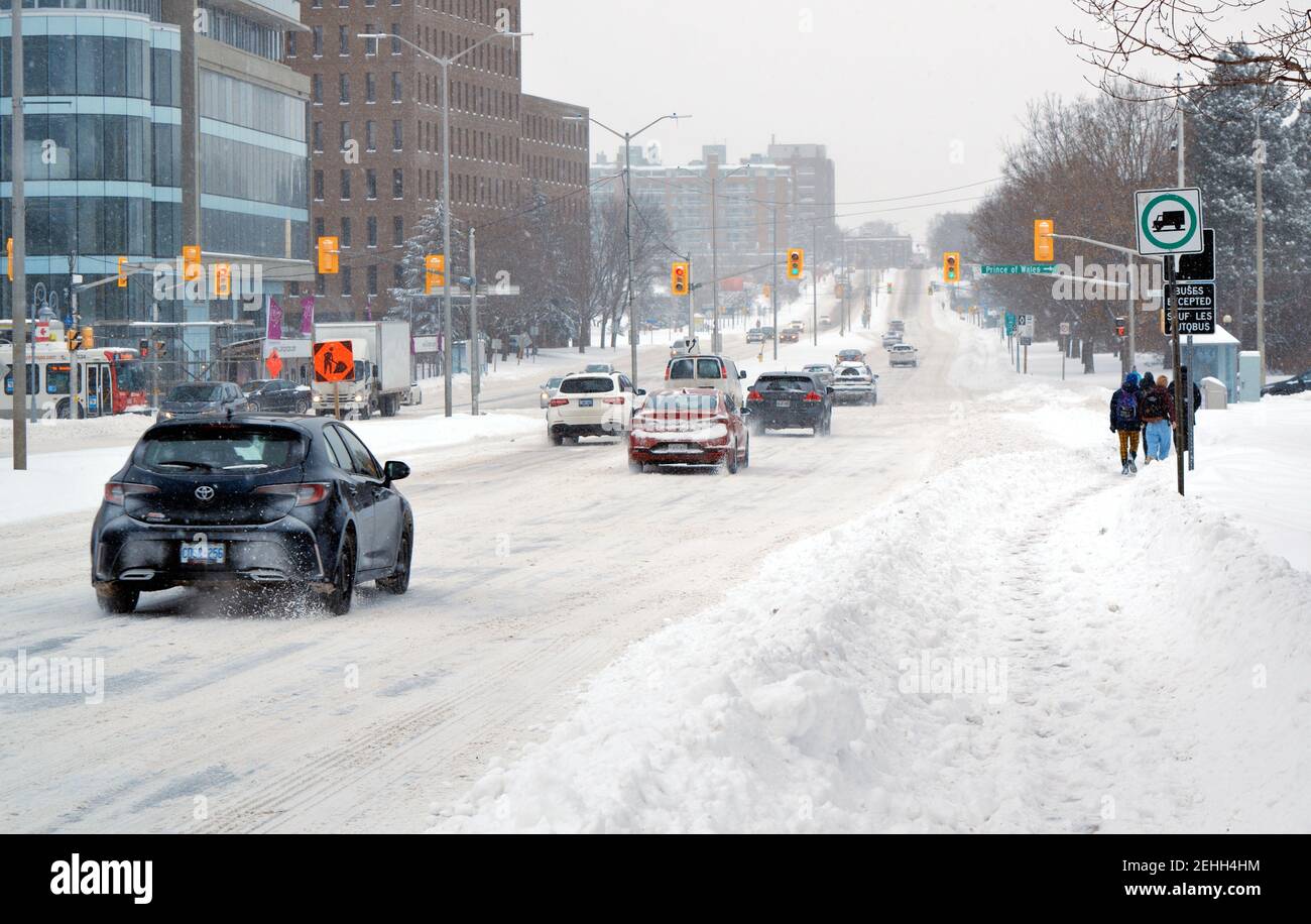 Life in a cold city - winterscapes from Ottawa - traffic (pedestrians & cars) struggle up Carling Ave on a snowy winter morning. Ontario, Canada. Stock Photo