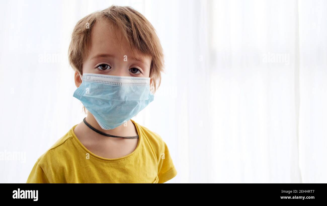 Young boy in mask white background looking at camera coronavirus