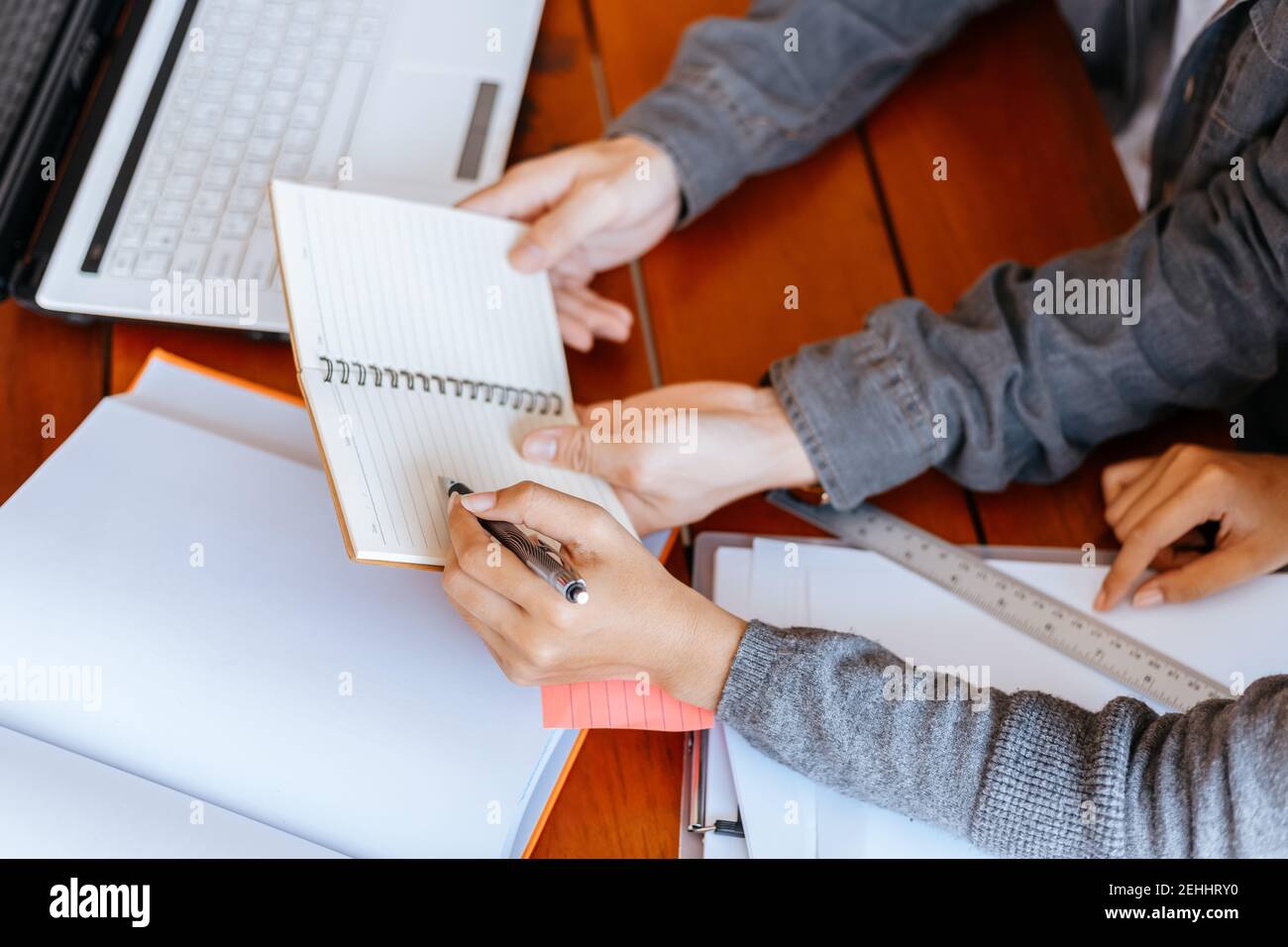 High school or college students  group catching up workbook and learning tutoring on desk and reading, doing homework, lesson practice preparing exam. Stock Photo