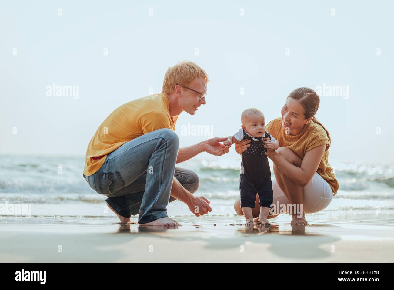 Happy family on the beach.  Father, mother and baby having fun on summer vacation. Holiday travel concept Stock Photo
