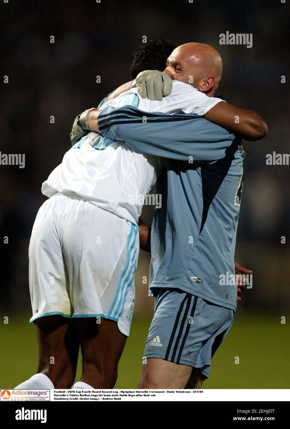 Football - UEFA Cup Fourth Round Second Leg - Olympique Marseille v Liverpool - Stade Velodrome - 25/3/04  Marseille's Fabien Barthez hugs his team mate Habib Beye after their win  Mandatory Credit : Action Images / Andrew Budd Stock Photo