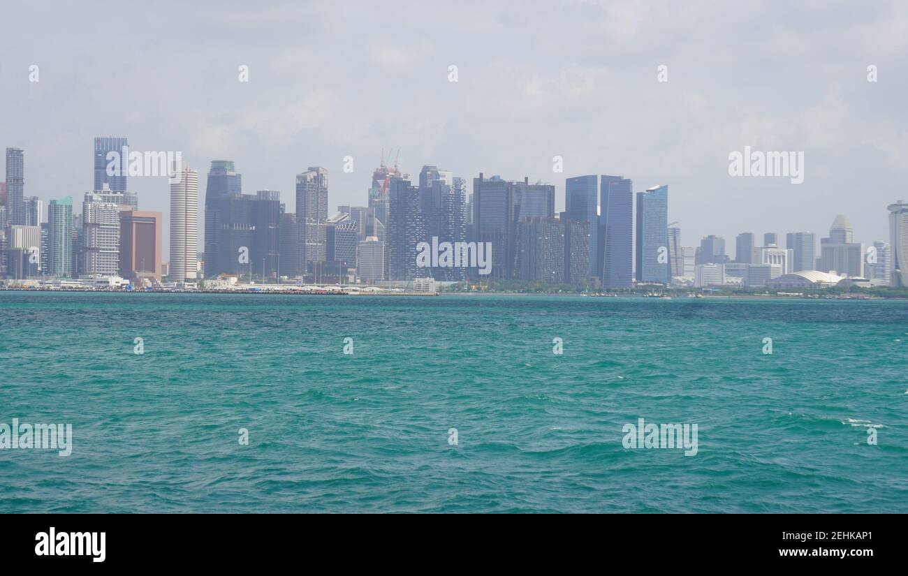 Beautiful landscape of Singapore showing tall buildings from sea with clean and green sea water Stock Photo