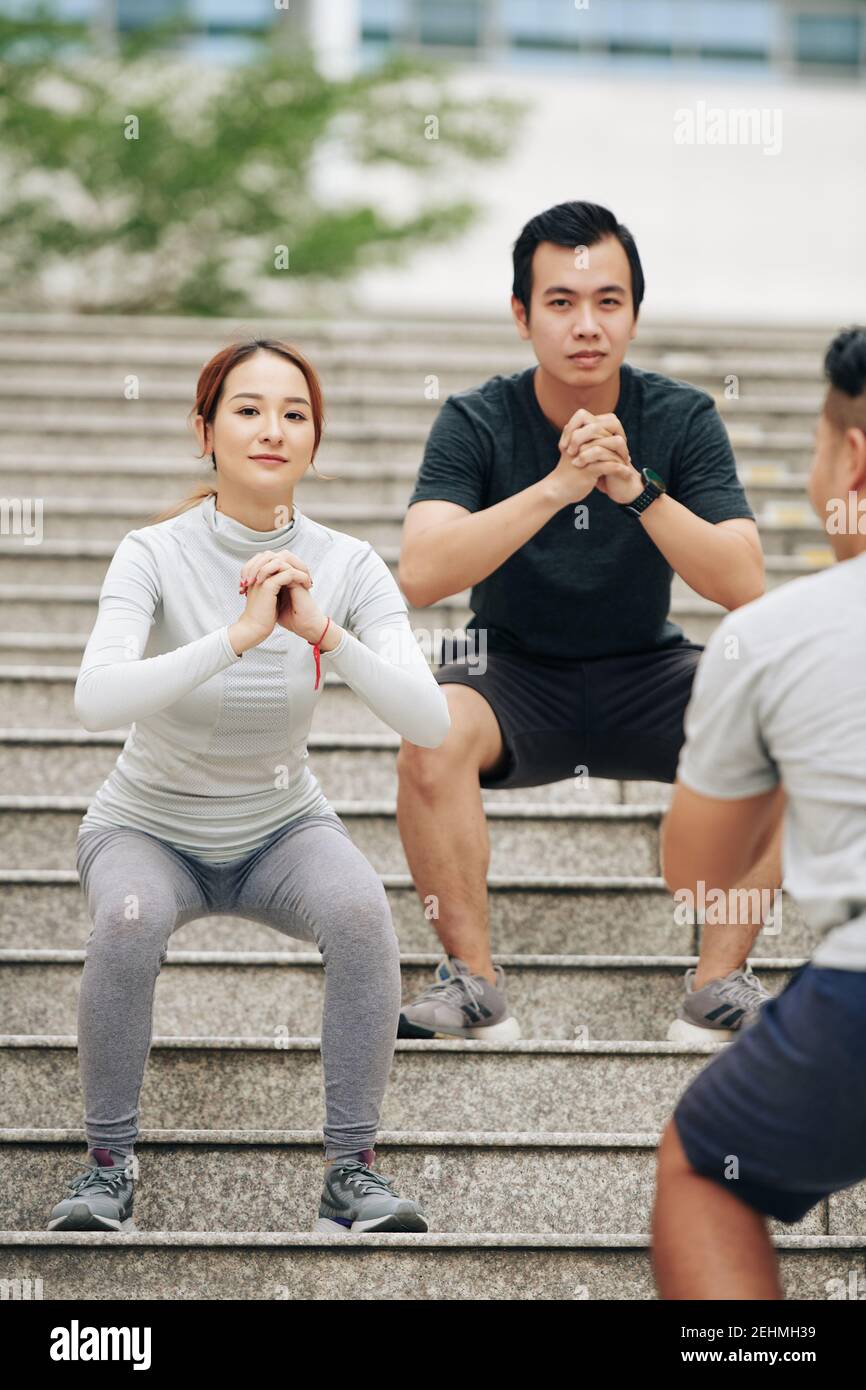 Couple doing squats on steps Stock Photo