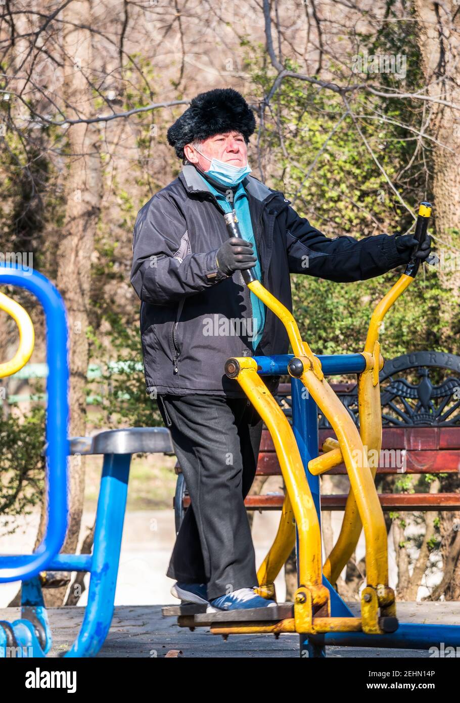 Bucharest, Romania -02.12.2021: Senior man working out on an elliptical cross trainer in Cismigiu park, Bucharest. Stock Photo