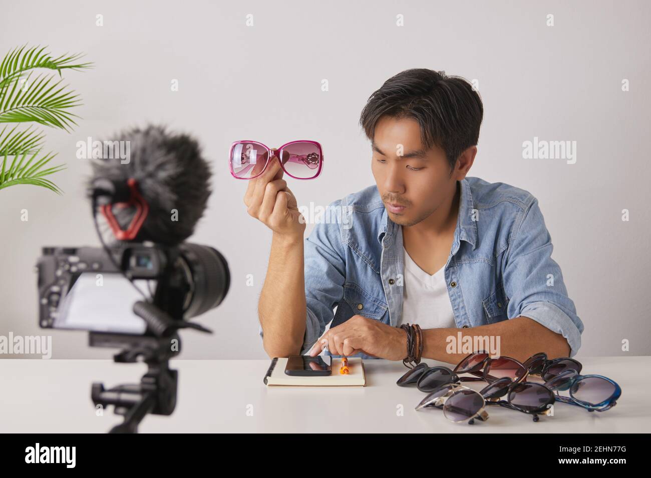 Asian Vlogger or Blogger Show Pink Fashion Glasses and Chat with Customer and Recording Video. Freelancer Online Live Streaming with Customer Via Soci Stock Photo