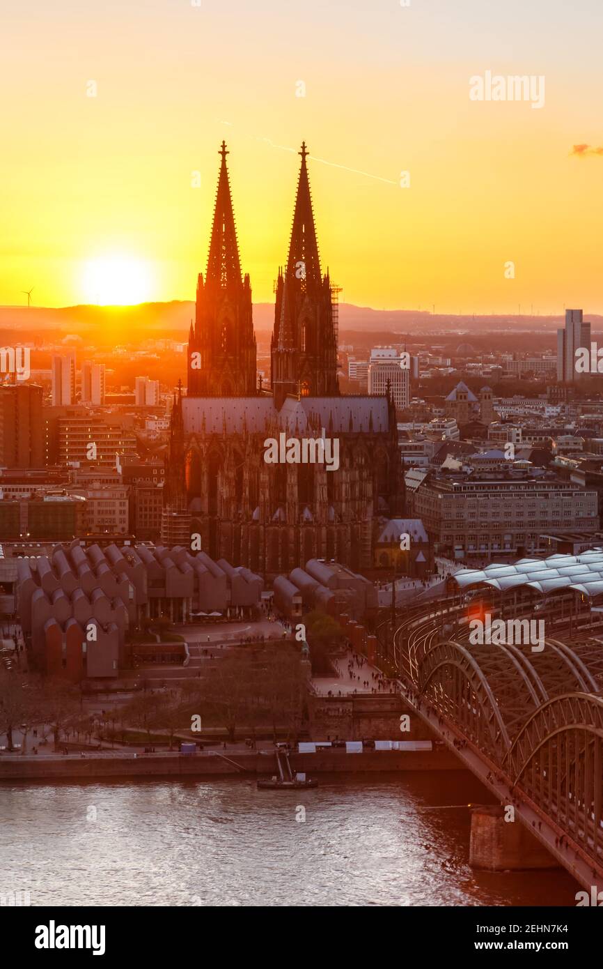 Cologne Cathedral church portrait format Germany skyline city town sunset bridge evening Stock Photo
