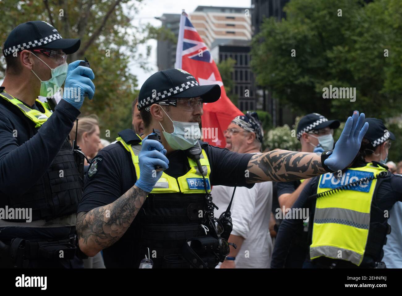 Melbourne, Australia. 20th Feb 2021. Police warn anti COVID vaccine marches to stay back with a can of capsicum spray. February 20, 2021. Melbourne, Australia. Credit: Jay Kogler/Alamy Live News Stock Photo