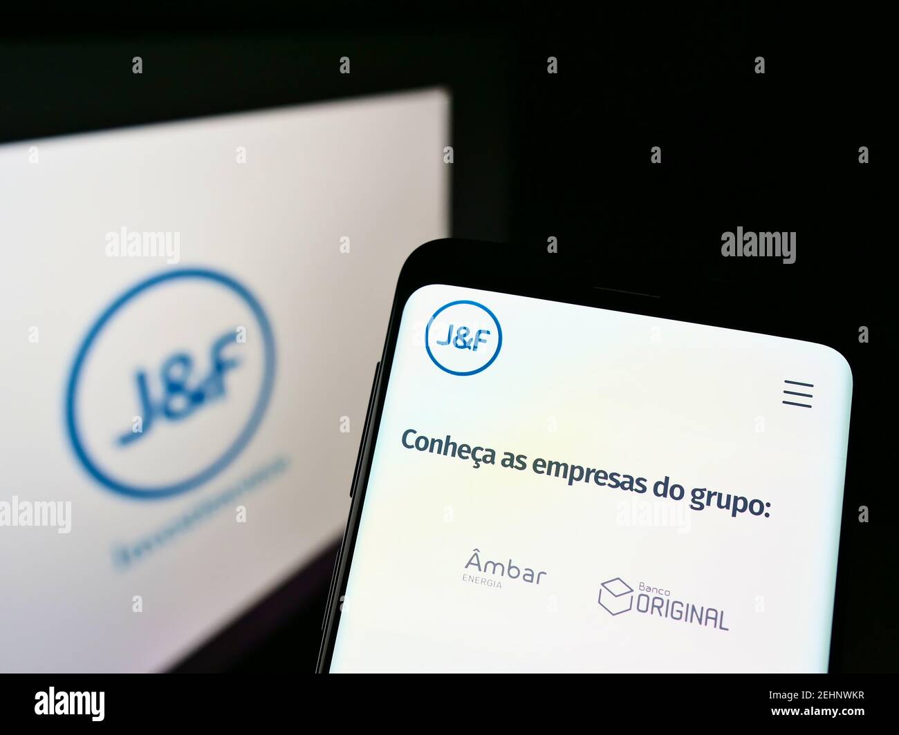 Mobile phone with web page of Brazilian investment company JF Investimentos SA on screen in front of logo. Focus on center of phone display. Stock Photo