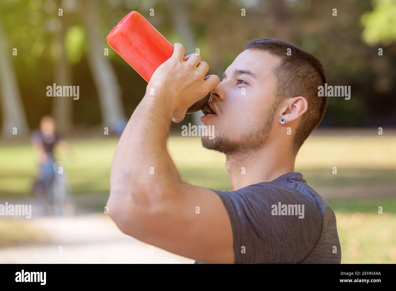 Drinking water runner young man drink jogger sports training fitness workout outdoor Stock Photo
