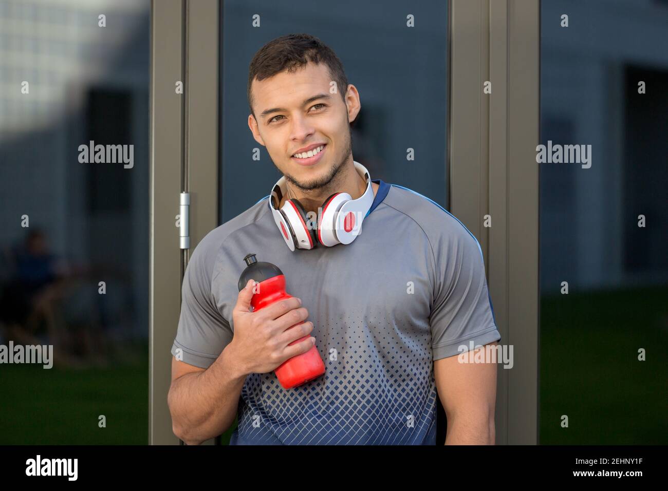 Smiling young latin man looking up runner outdoor sports fitness training outside Stock Photo