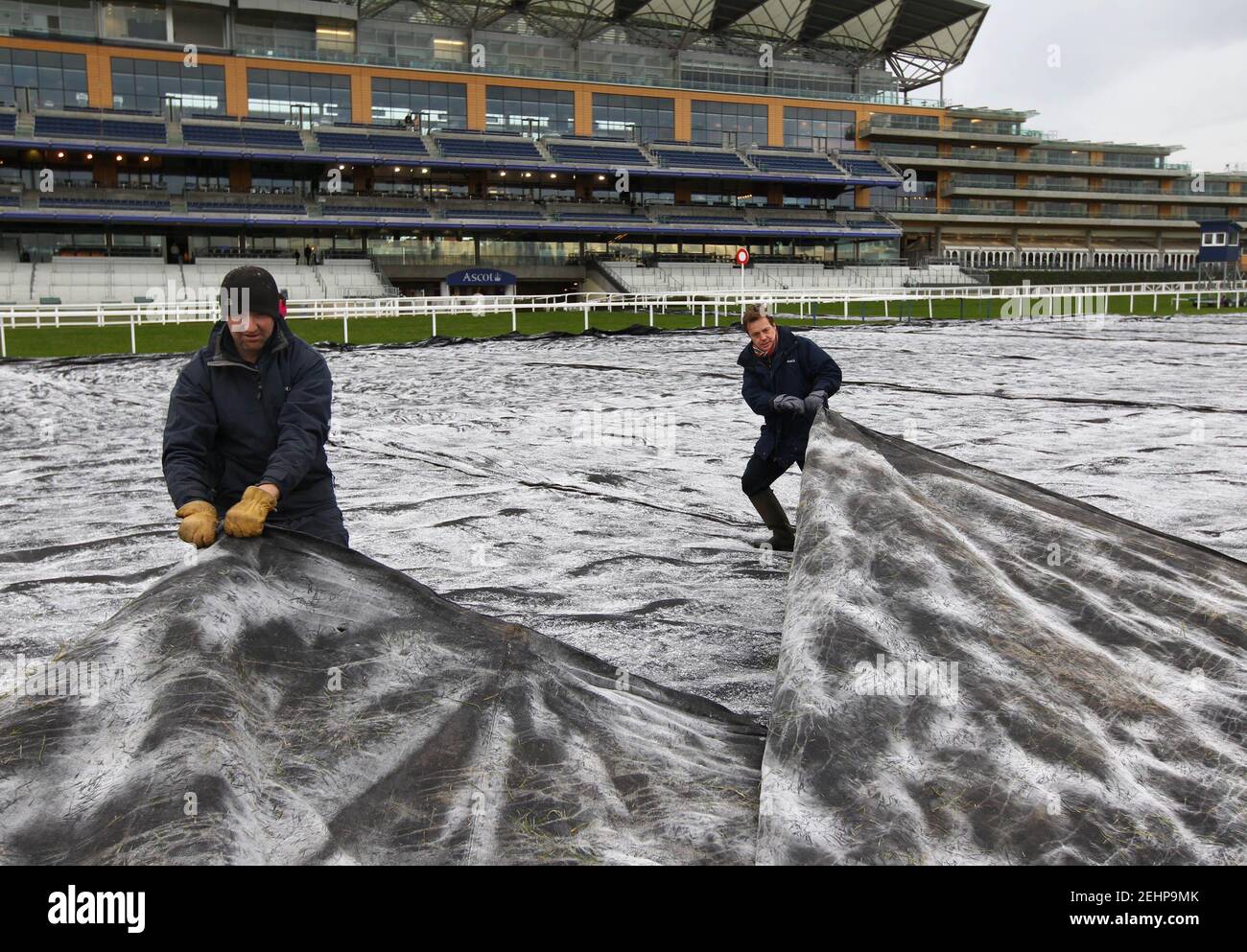Horse Racing - Ascot  - Ascot Racecourse - 17/12/10  Clerk of The Course Chris Stickels (R) and a groundsman remove a frost cover. The course passed an early morning inspection but racing was abandoned after temperatures failed to rise sufficiently to remove the frost covers.  Mandatory Credit: Action Images / Julian Herbert  Livepic Stock Photo