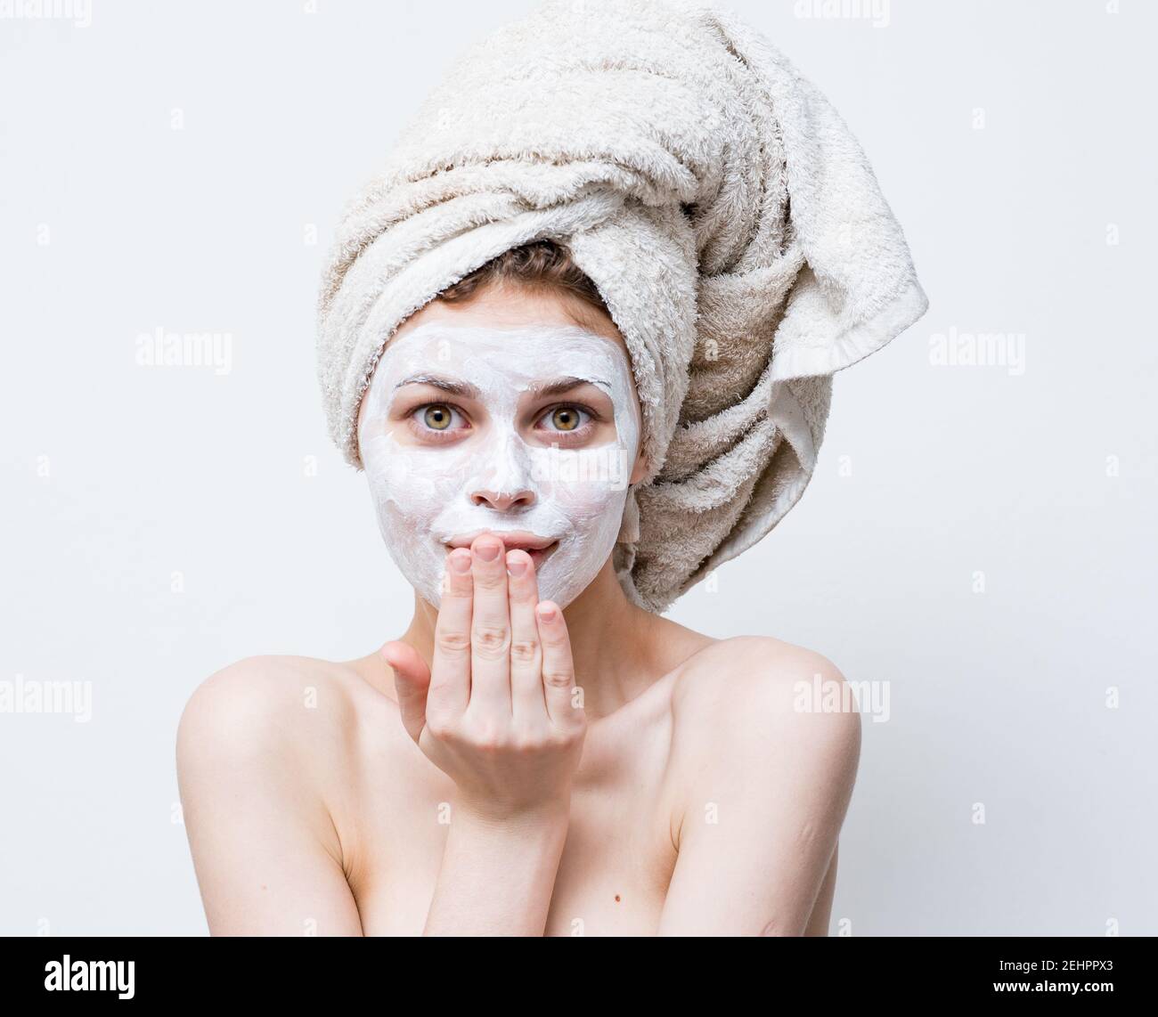 pretty woman with a towel on her head and a white mask against black