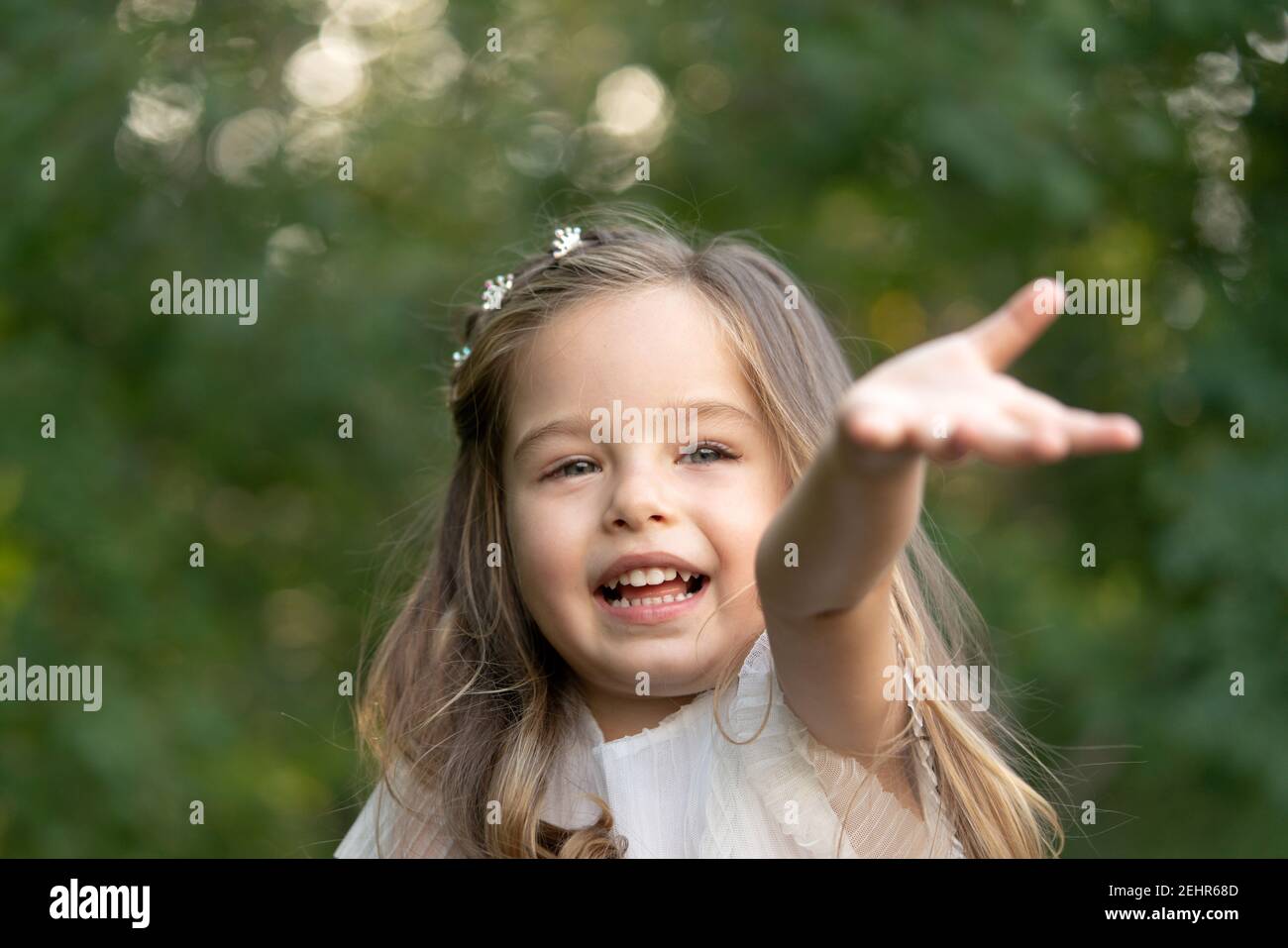 Cute child girl need help and pulling hand arm reach out to camera