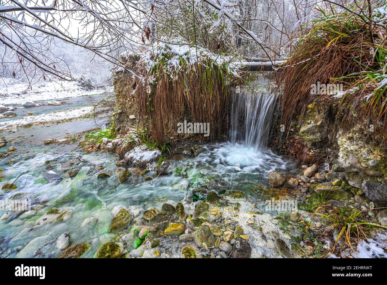 Waterfall of hot sulphurous water in a snowy landscape. Sources of the Lavino, Maiella National Park, Abruzzo Stock Photo