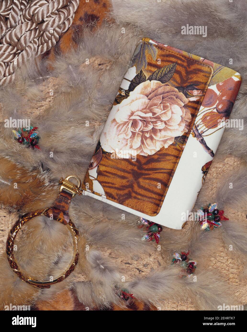 Elegant vintage women's handbag with flowers motive on a leather long haired carpet. Stock Photo