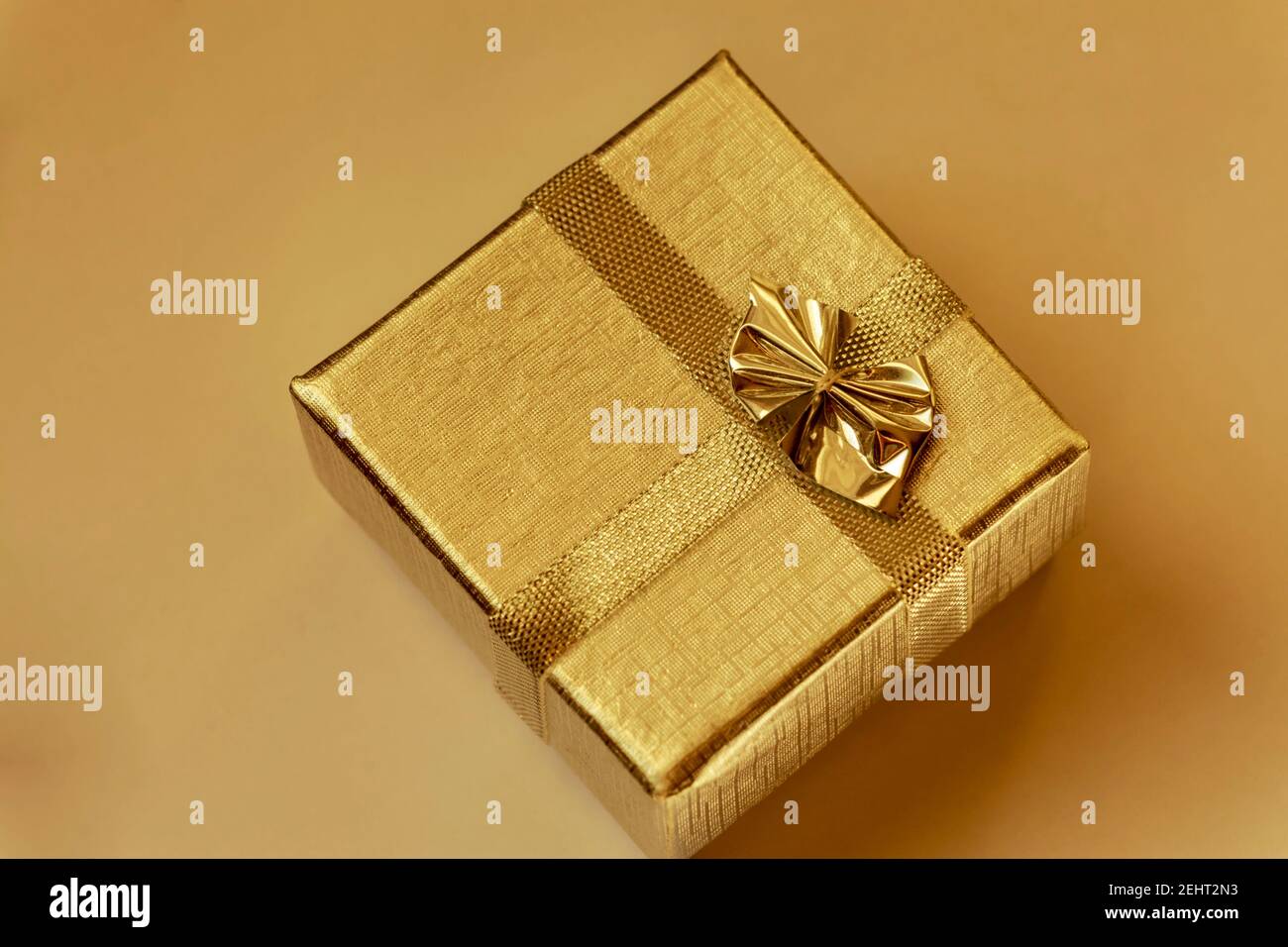 Golden box with golden ribbon Stock Photo