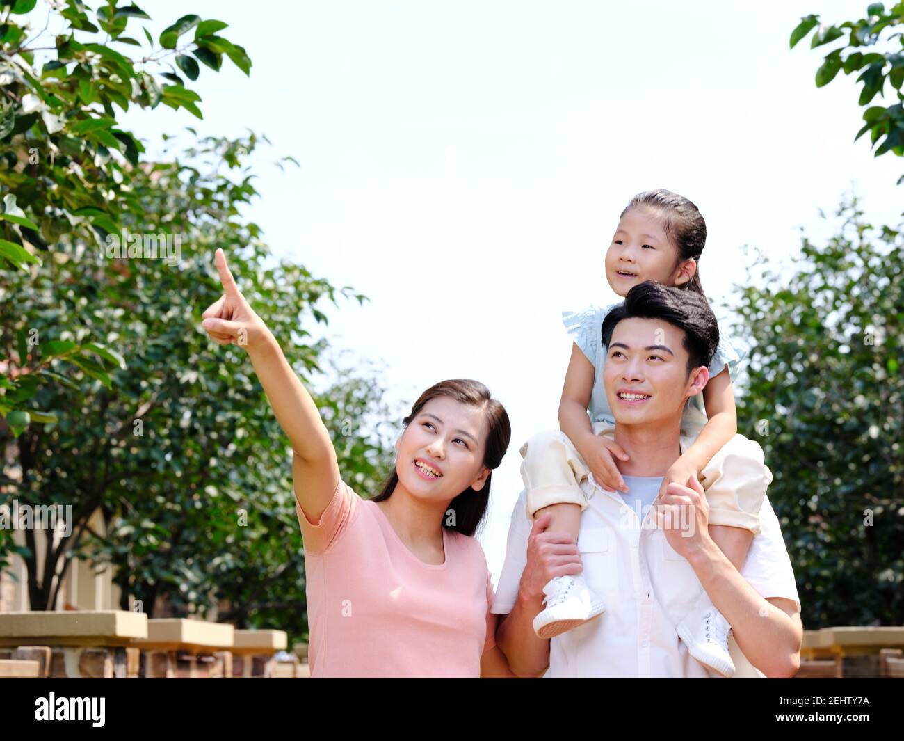 Happy family of three in the outdoor pointing Stock Photo - Alamy