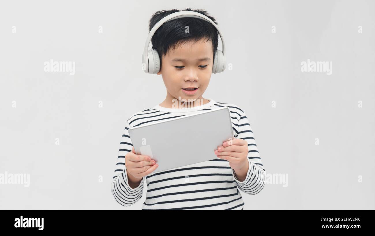 Boy with electronic pad and phones. Isolated on white Stock Photo