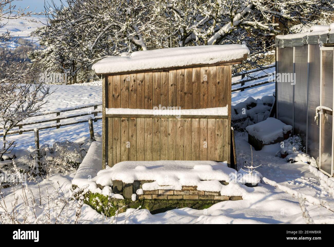 A small wooden stable surrounded by snow Stock Photo