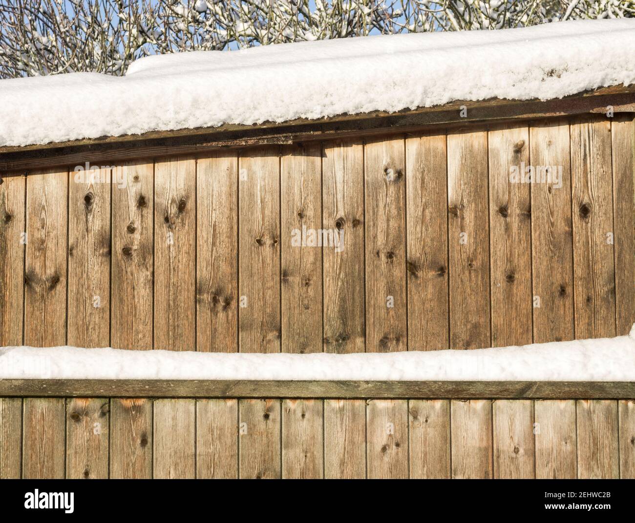 A close up of a wooden stable with snow on the roof Stock Photo