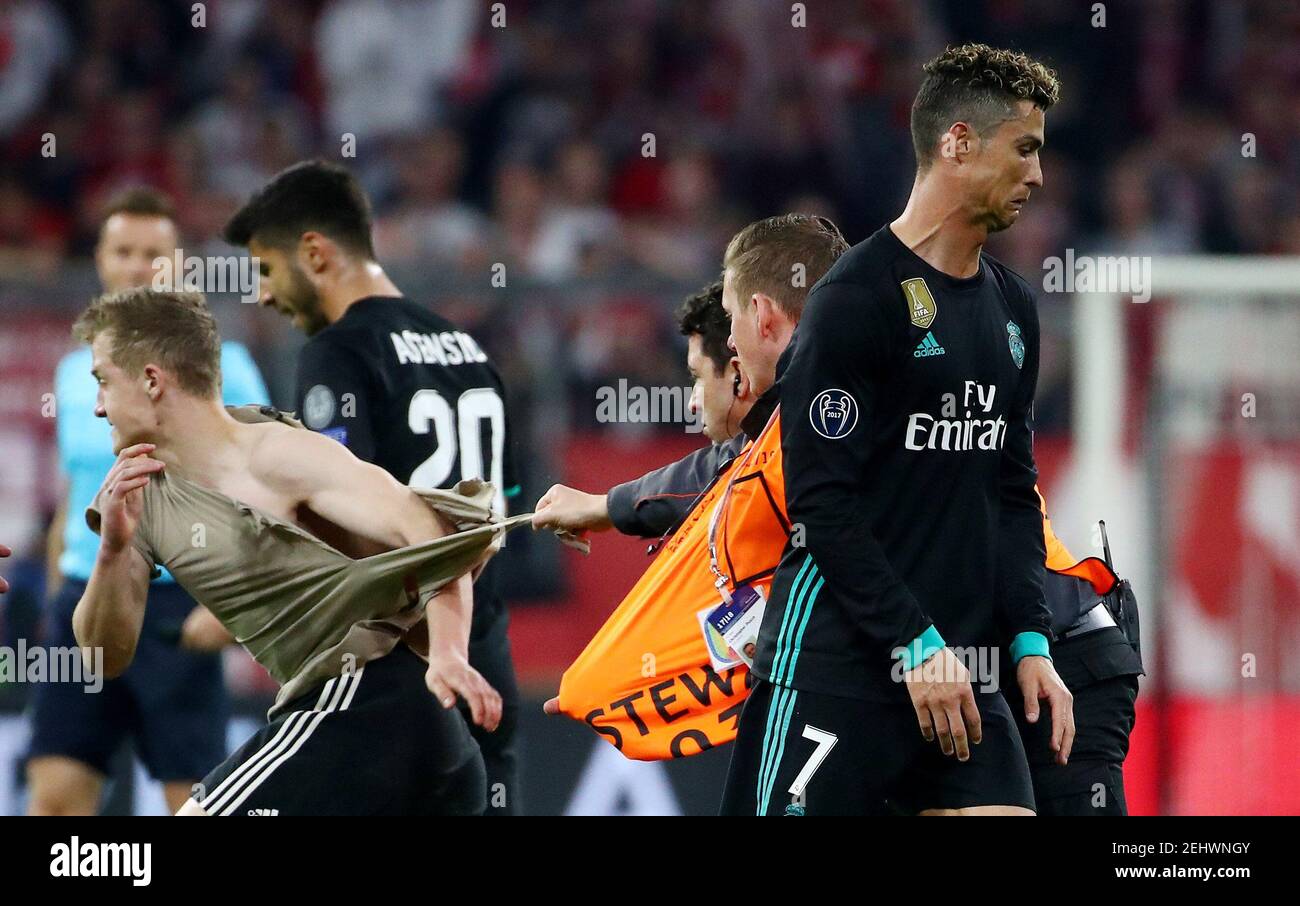 Soccer Football - Champions League Semi Final First Leg - Bayern Munich vs Real Madrid - Allianz Arena, Munich, Germany - April 25, 2018   Real Madrid's Cristiano Ronaldo walks past as stewards chase a pitch invader after the match    REUTERS/Michael Dalder Stock Photo