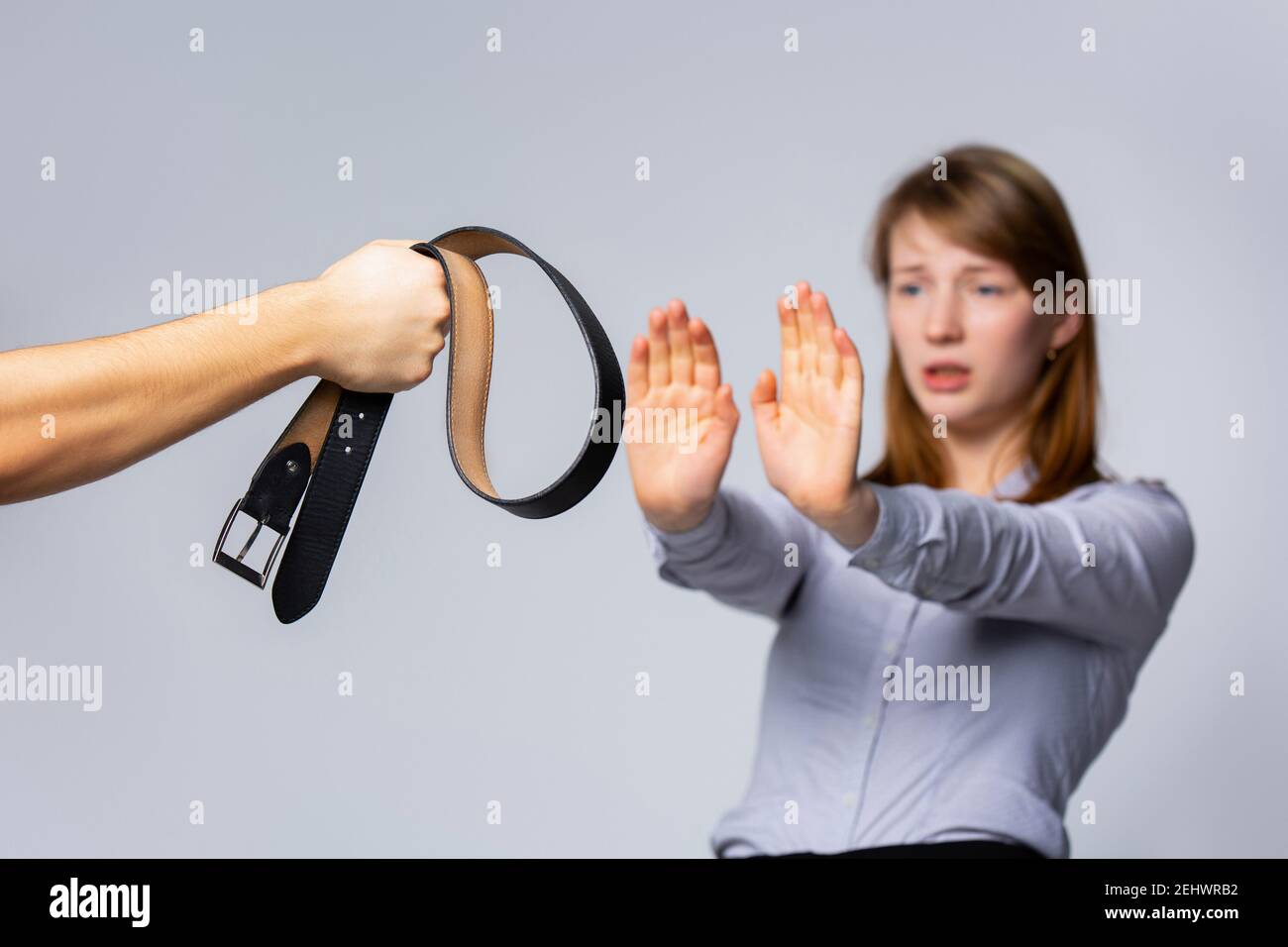 Abused, scary blonde, unhappy married, young suffering woman showing Stop hands. Sign of discrimination or anti violence symbol on grey background Stock Photo
