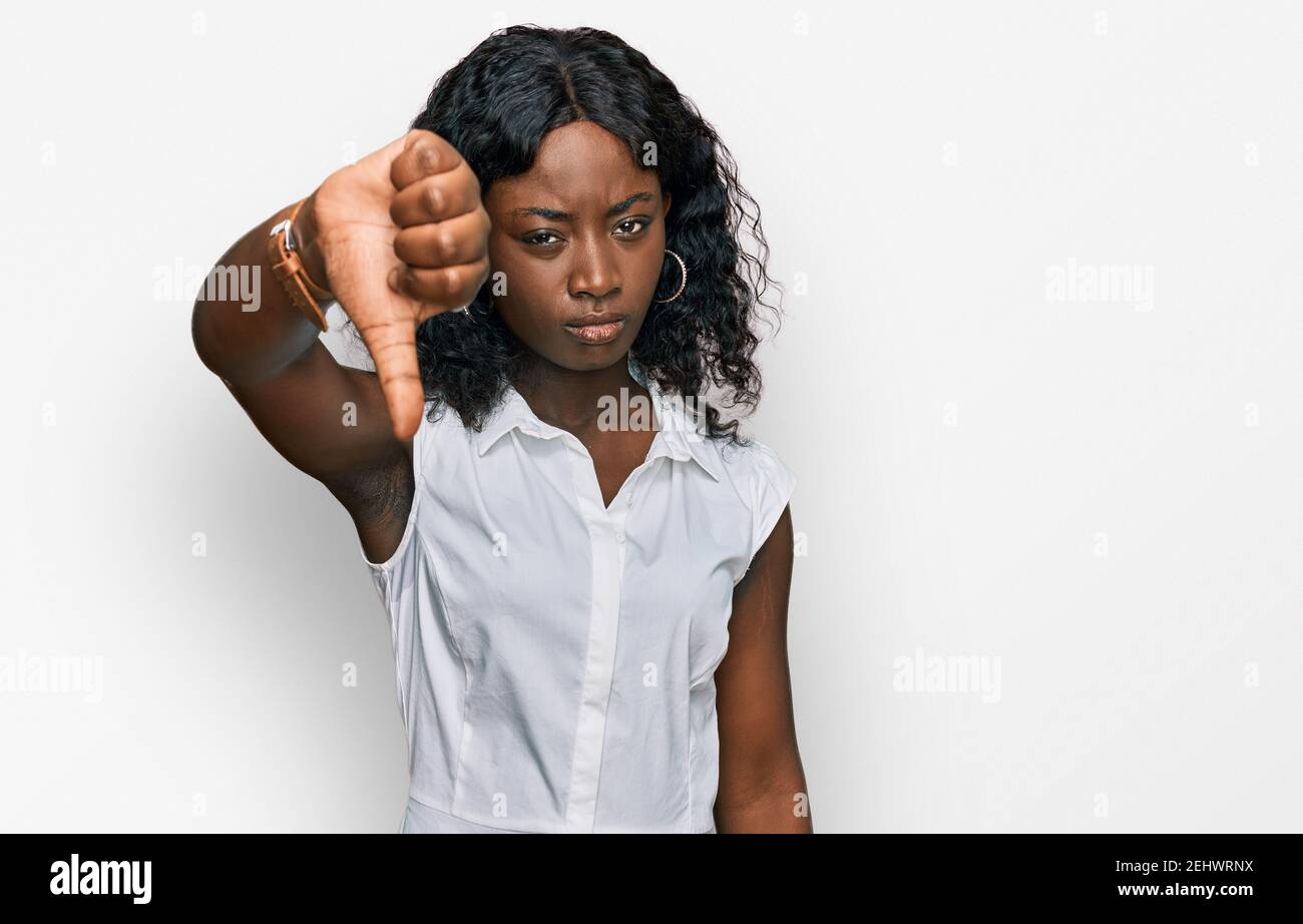 Beautiful african young woman wearing casual clothes looking unhappy ...