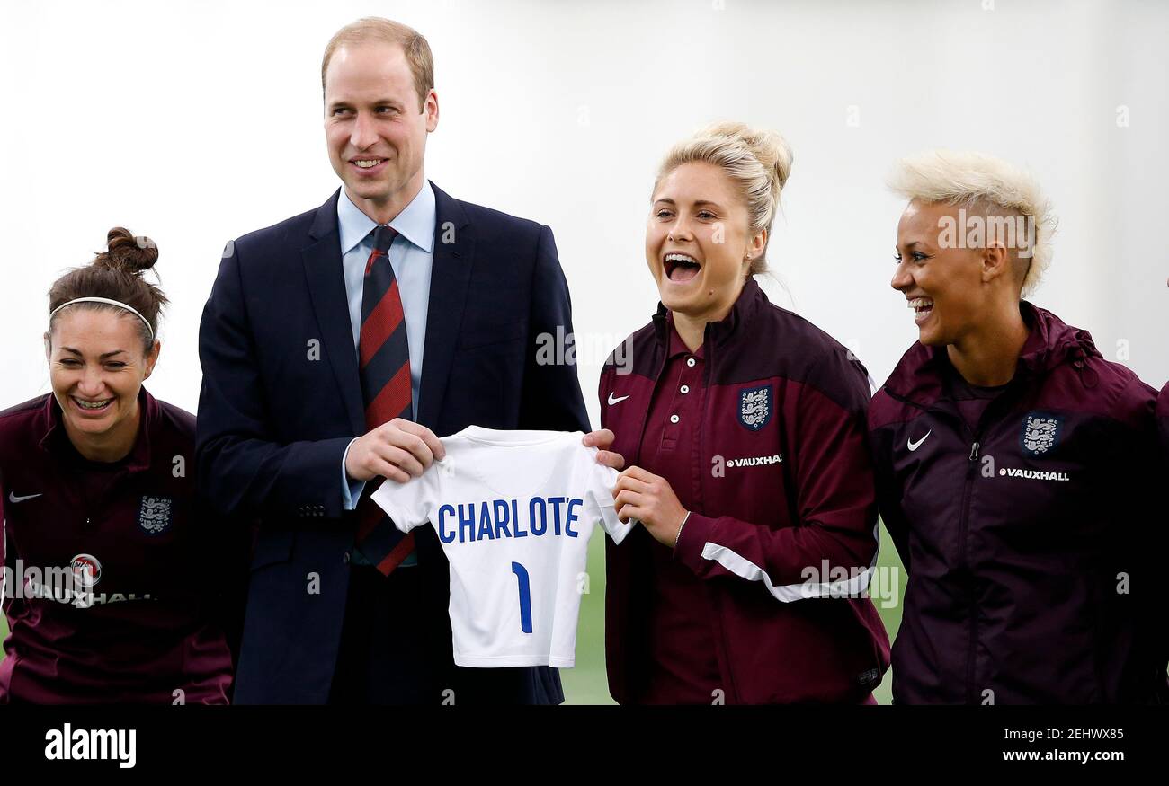 Football - The Duke of Cambridge meets the England Women Senior Team at St George's Park as they train for the FIFA Women's World Cup - St. George?s Park, Burton Upon Trent - 20/5/15 The Duke of Cambridge is presented with an England football shirt for his daughter Charlotte by England's Stephanie Houghton as her team mates look on Action Images via Reuters / Carl Recine Livepic EDITORIAL USE ONLY. Stock Photo