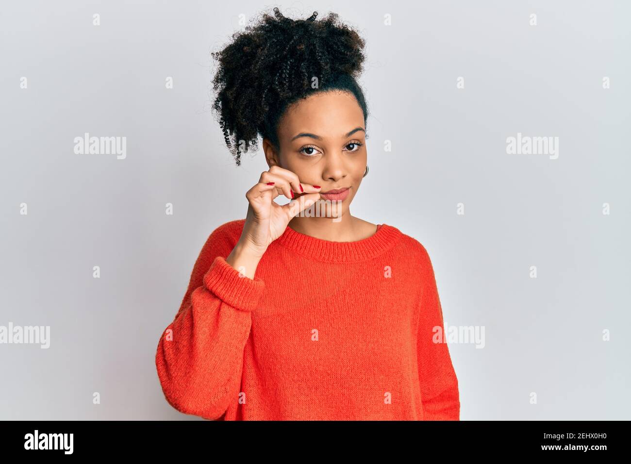 Young african american girl wearing casual clothes mouth and lips shut as  zip with fingers. secret and silent, taboo talking Stock Photo - Alamy