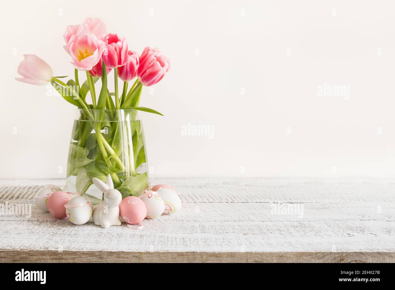 Spring Easter composition with pink tulips and eggs on light background. Space for text. Stock Photo
