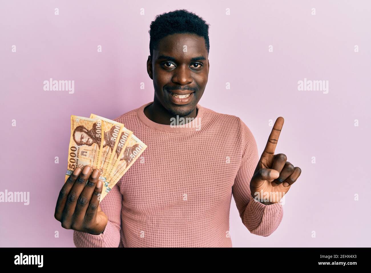 handsome-black-man-holding-5000-hungarian-forint-banknotes-smiling-with