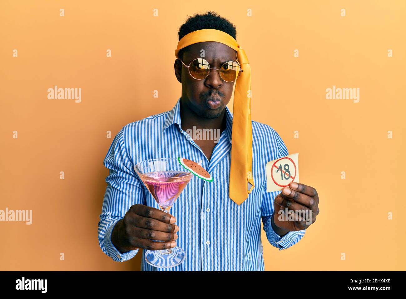 Handsome black man drunk wearing tie over head drinking cocktail ...
