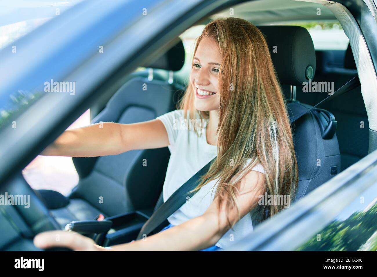 Young beautiful blonde woman smiling happy driving car Stock Photo - Alamy