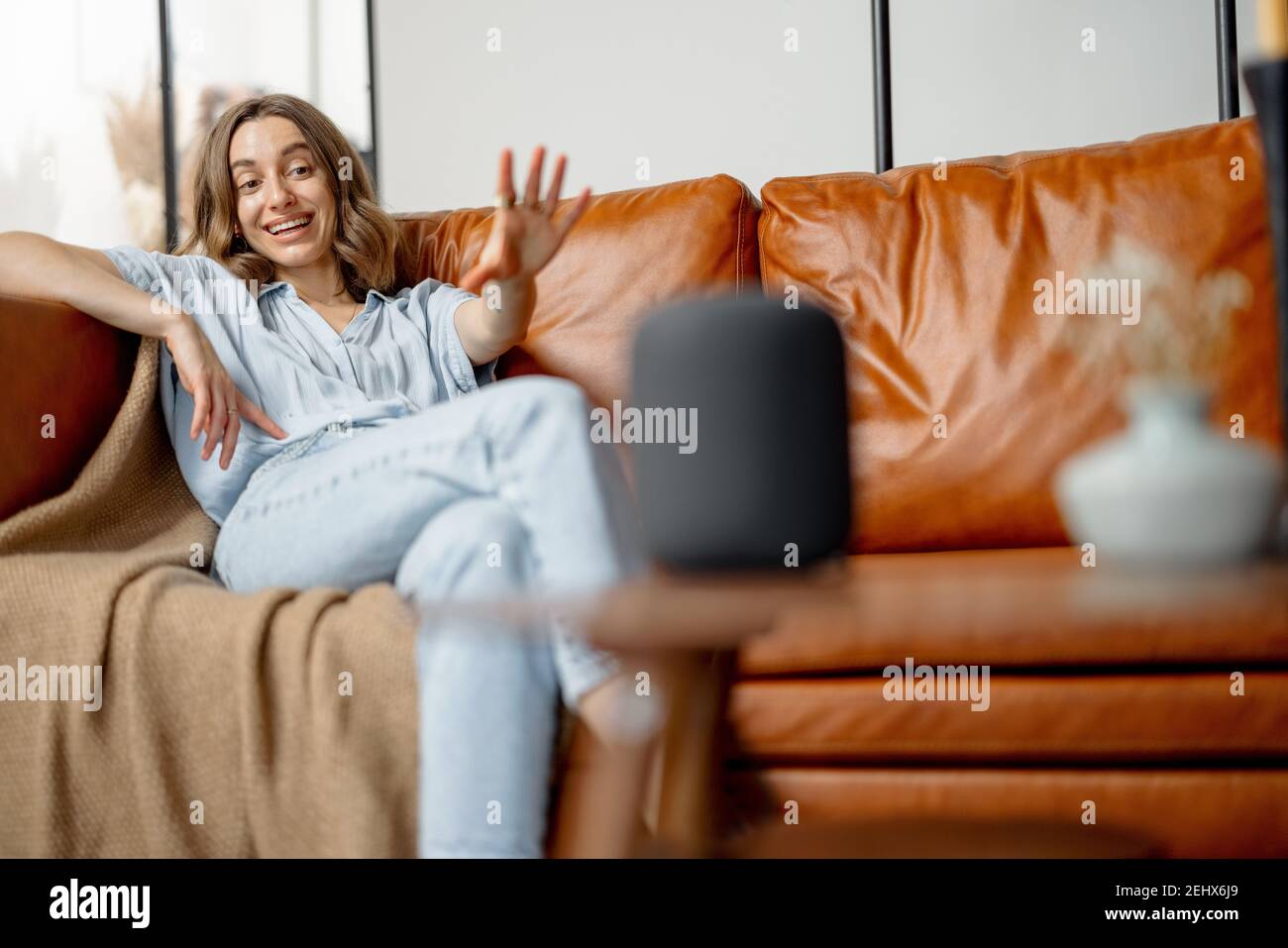 Woman speaking with audio assistant column Stock Photo