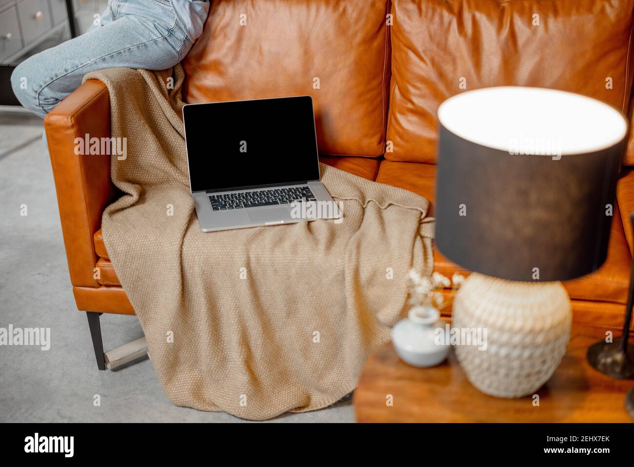 Open laptop lying on foxy leather sofa at home Stock Photo - Alamy