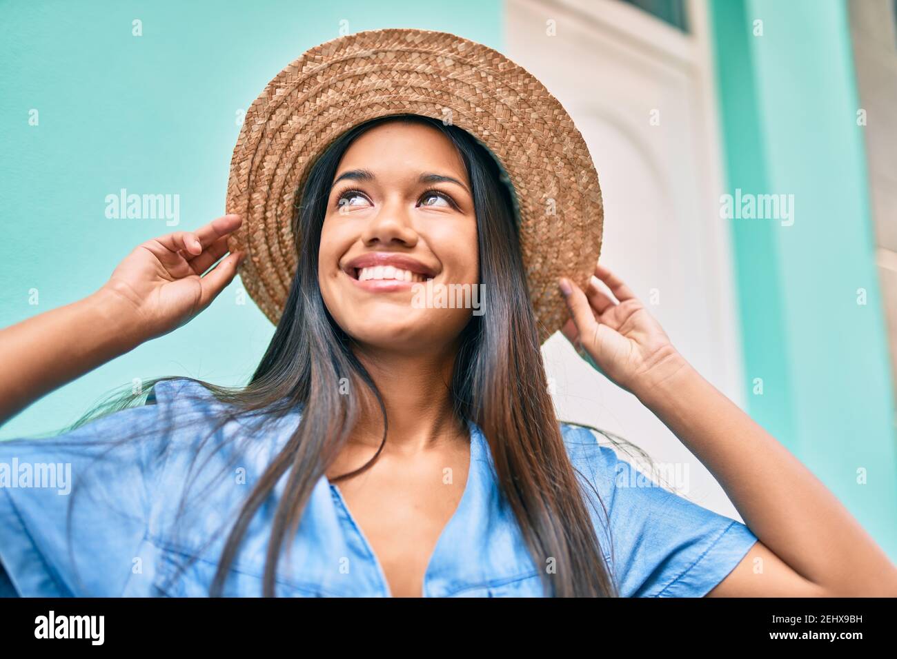 Young latin tourist girl on vacation smiling happy walking at the city ...
