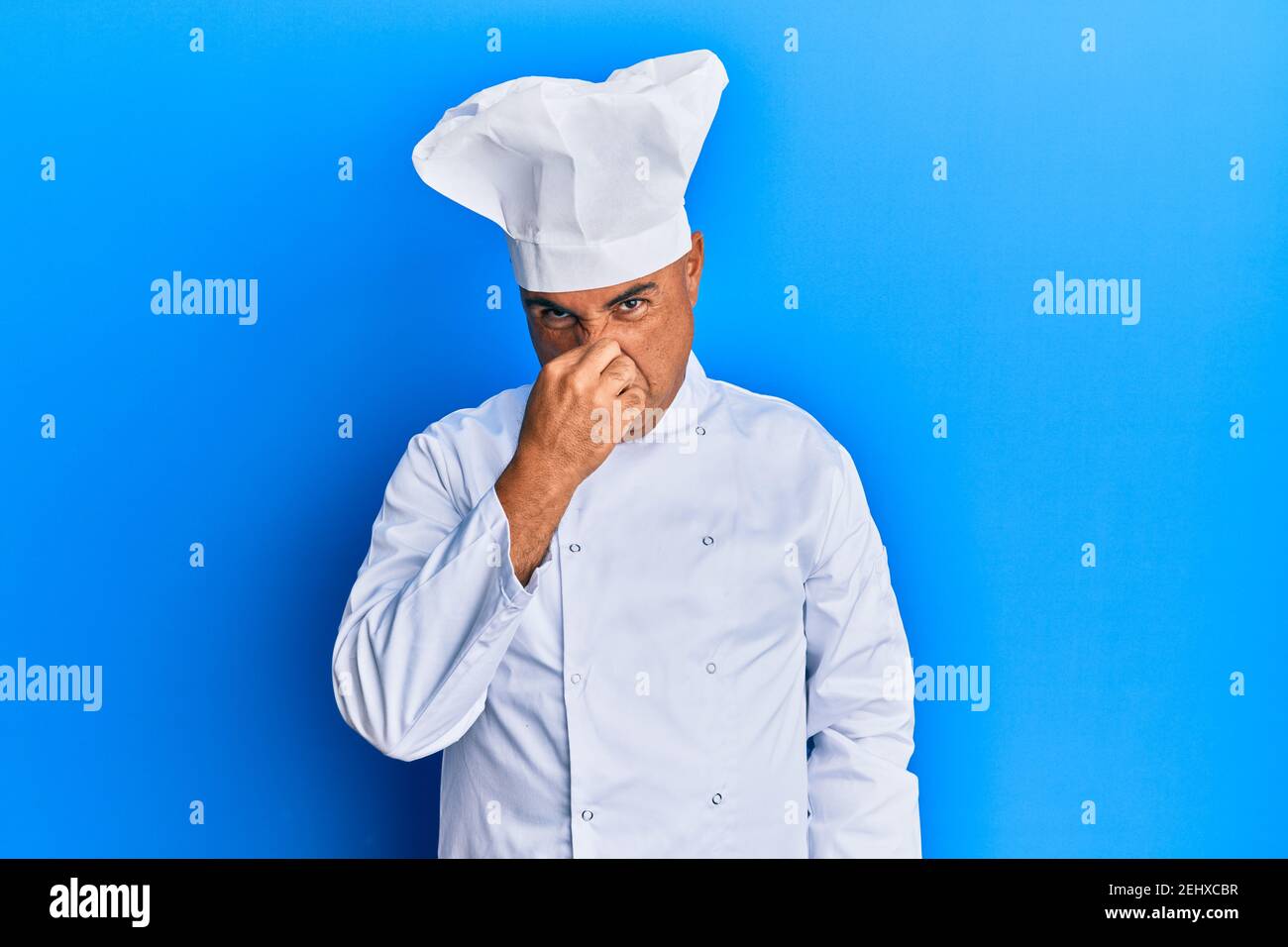 Mature middle east man wearing professional cook uniform and hat ...