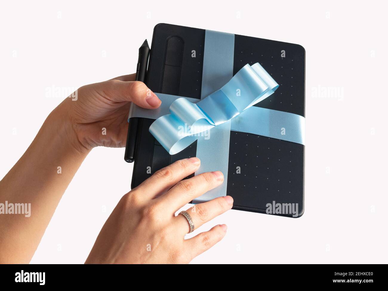 gift wrapped digital tablet with blue bow with hands delivering it Stock Photo