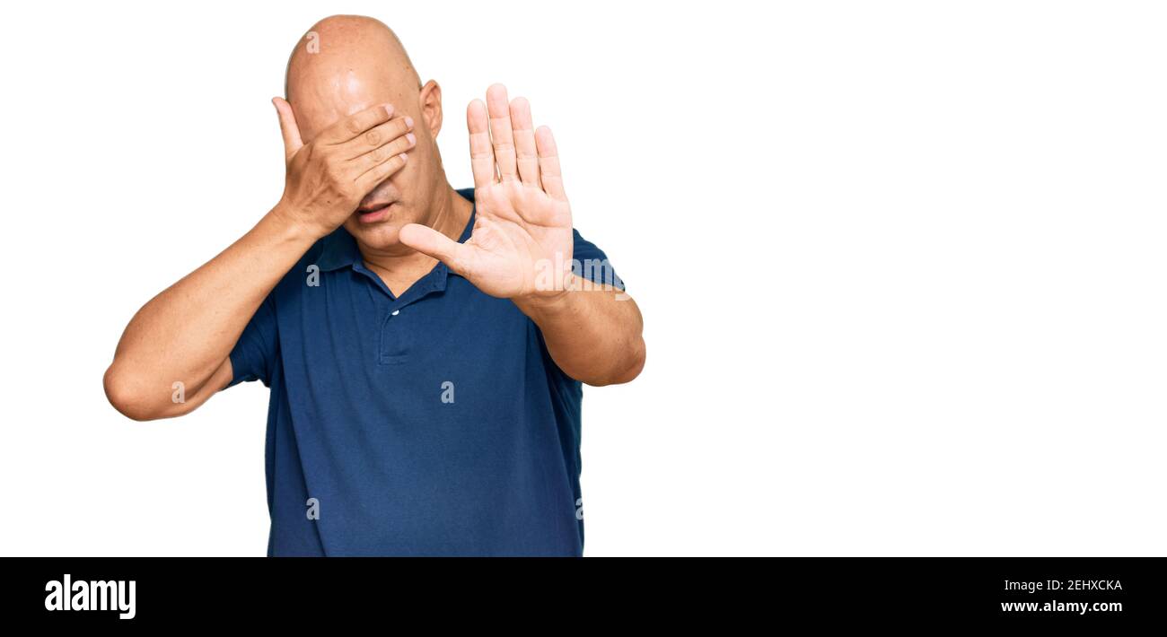 Middle age bald man wearing casual clothes covering eyes with hands and doing stop gesture with sad and fear expression. embarrassed and negative conc Stock Photo