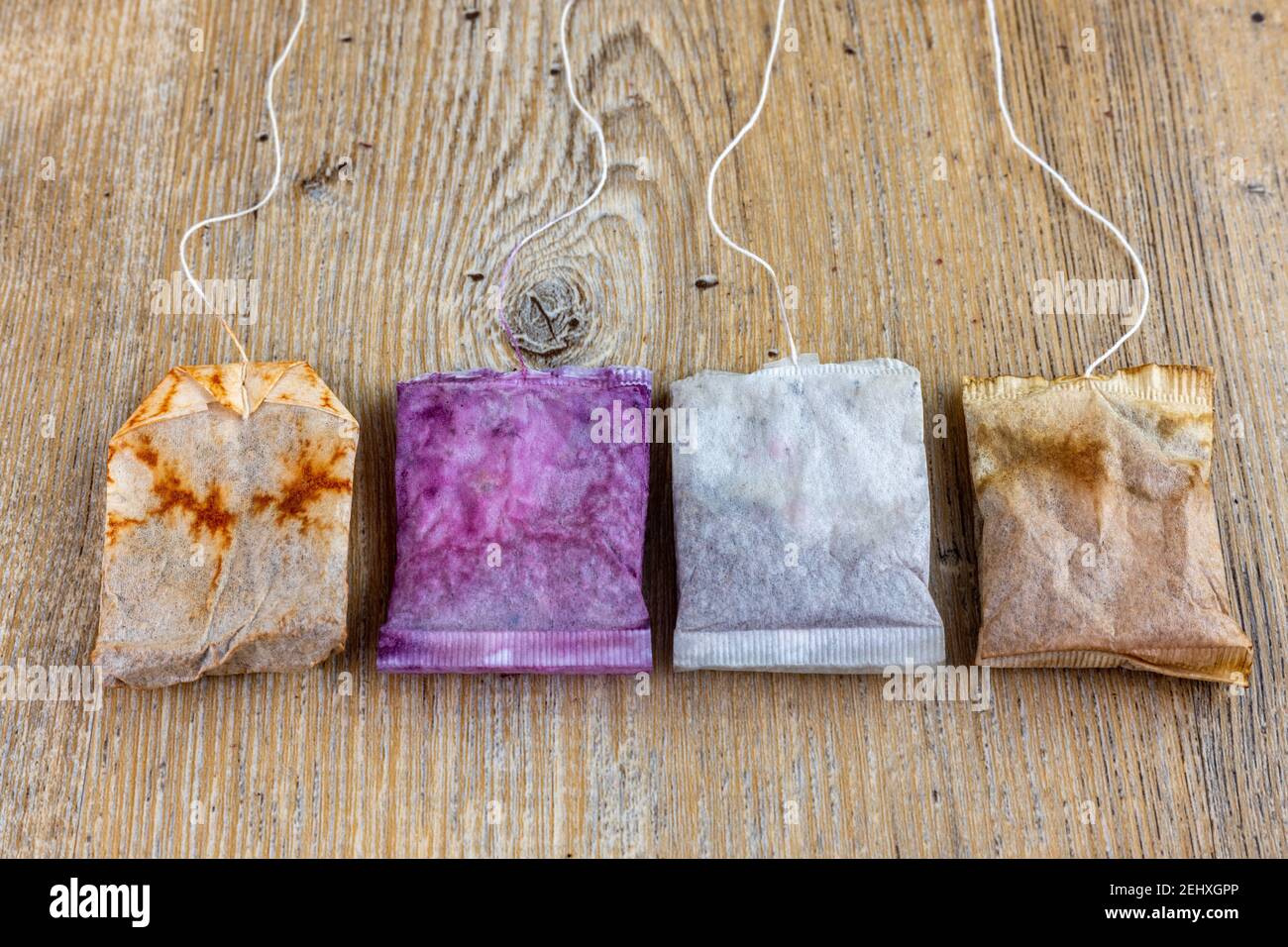 close up of used and new tea bags lined up on wooden table Stock Photo
