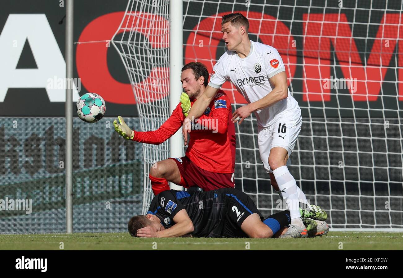 Paderborn, Germany. 20th Feb, 2021. Football: 2nd Bundesliga, SC Paderborn 07 - SV Sandhausen, Matchday 22 at Benteler Arena. Paderborn's Uwe Hünemeier (below) and goalkeeper Leopold Zingerle (M) fight for the ball with Sandhausen's Kevin Behrens (r). Credit: Friso Gentsch/dpa - IMPORTANT NOTE: In accordance with the regulations of the DFL Deutsche Fußball Liga and/or the DFB Deutscher Fußball-Bund, it is prohibited to use or have used photographs taken in the stadium and/or of the match in the form of sequence pictures and/or video-like photo series./dpa/Alamy Live News Stock Photo